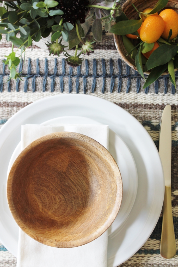 rustic table setting from all modern wood bowls, gold flatwear & kilim tablerunner