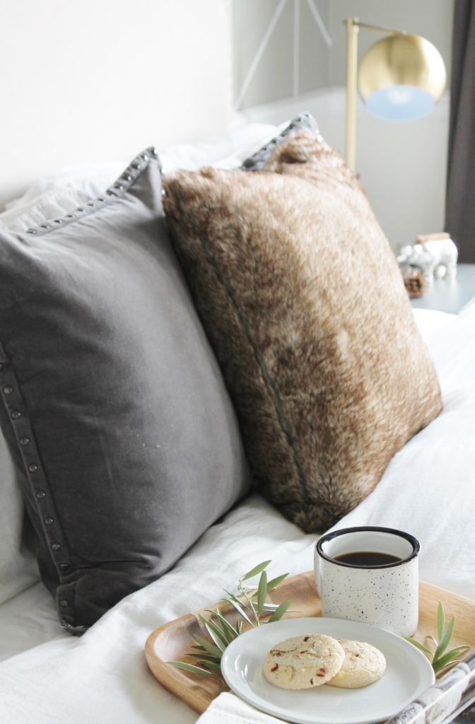 simple modern farmhouse holiday bedroom. Christmas decorating. Pine cone wreath, fresh greenery, plaid & cozy details