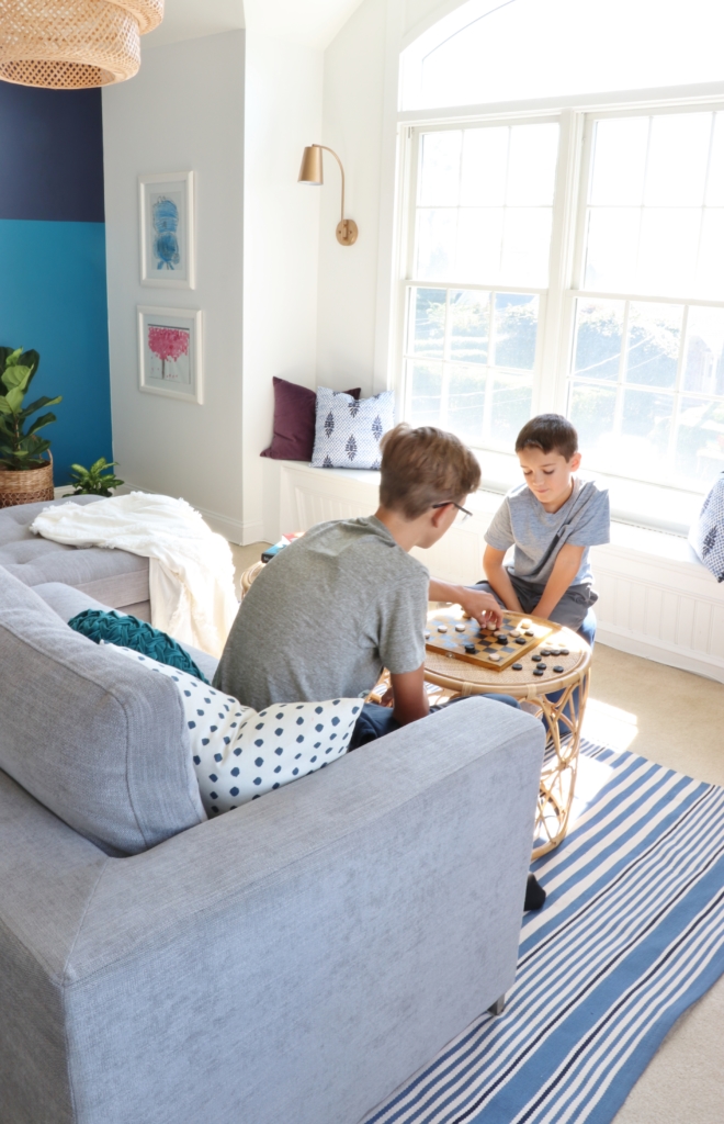 modern sofa bed-Soma by Article in Dawn Gray. Playroom updates including brass sconces & rattan pendant. Rattan side tables with navy striped rug.