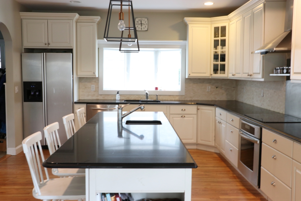 White Kitchen Renovation. HanStone Quartz, Montauk. White painted cabinets, black hardware