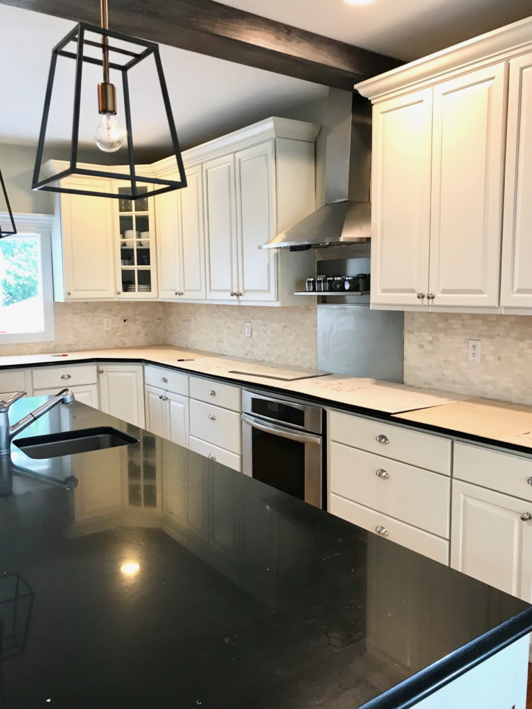 White Kitchen Renovation. HanStone Quartz, Montauk. White painted cabinets, black hardware