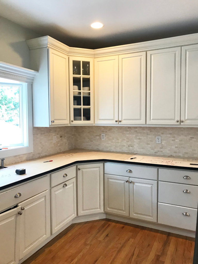 White Kitchen Renovation. HanStone Quartz, Montauk. White painted cabinets, black hardware