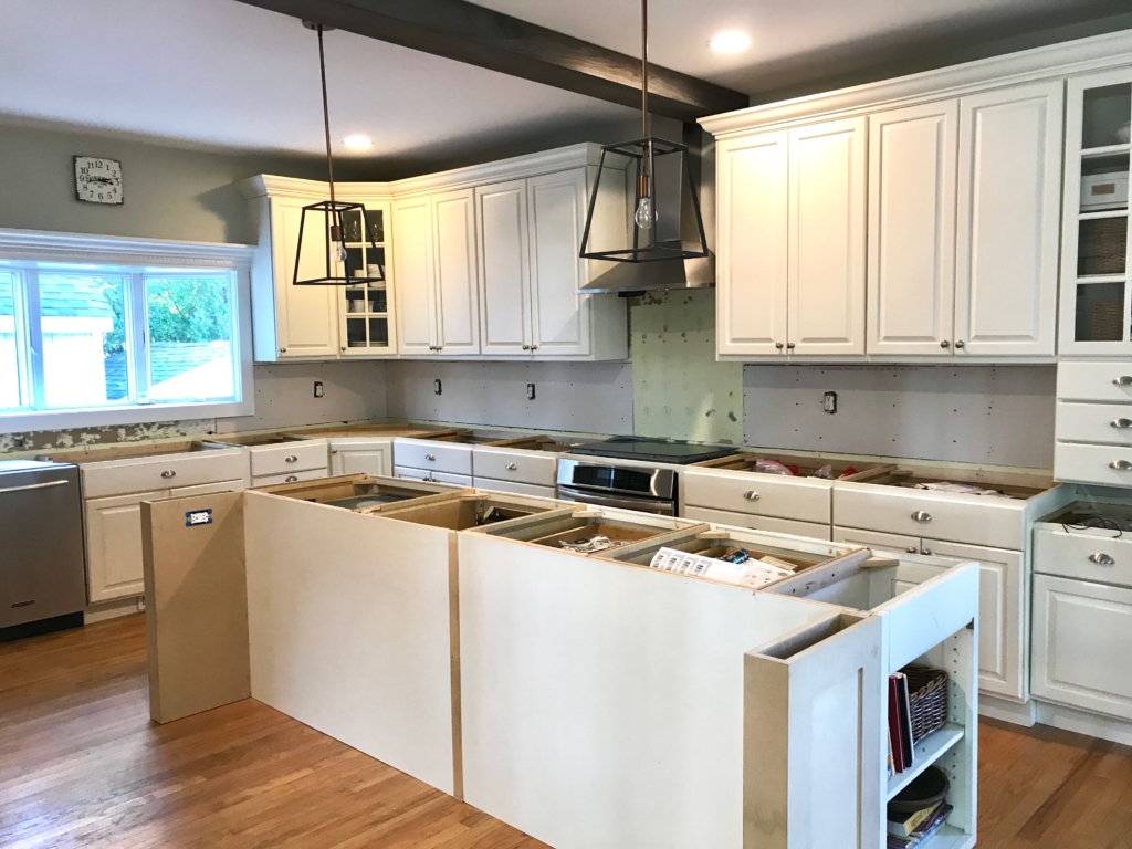 White Kitchen Renovation. HanStone Quartz, Montauk. White painted cabinets, black hardware