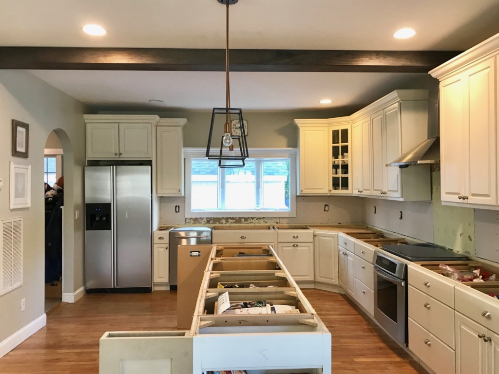 White Kitchen Renovation. HanStone Quartz, Montauk. White painted cabinets, black hardware