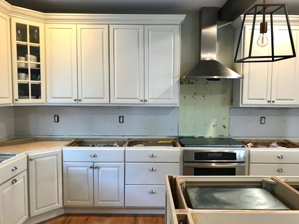 White Kitchen Renovation. HanStone Quartz, Montauk. White painted cabinets, black hardware