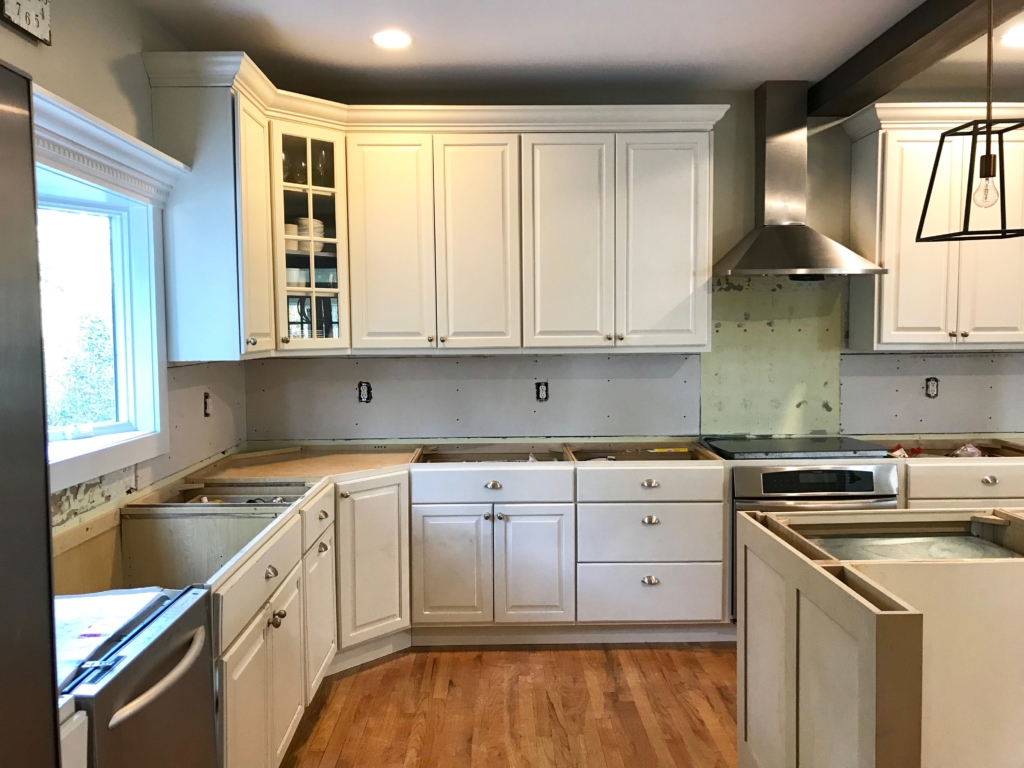 White Kitchen Renovation. HanStone Quartz, Montauk. White painted cabinets, black hardware