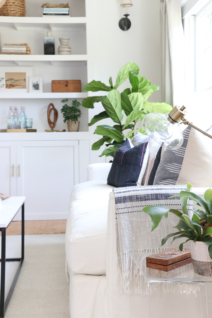 Denman Chair Article, White Slipcovered sofa, Woven Shade, White Walls, City Farmhouse & Co Pillows, Hats on Wall, Indigo Pillows