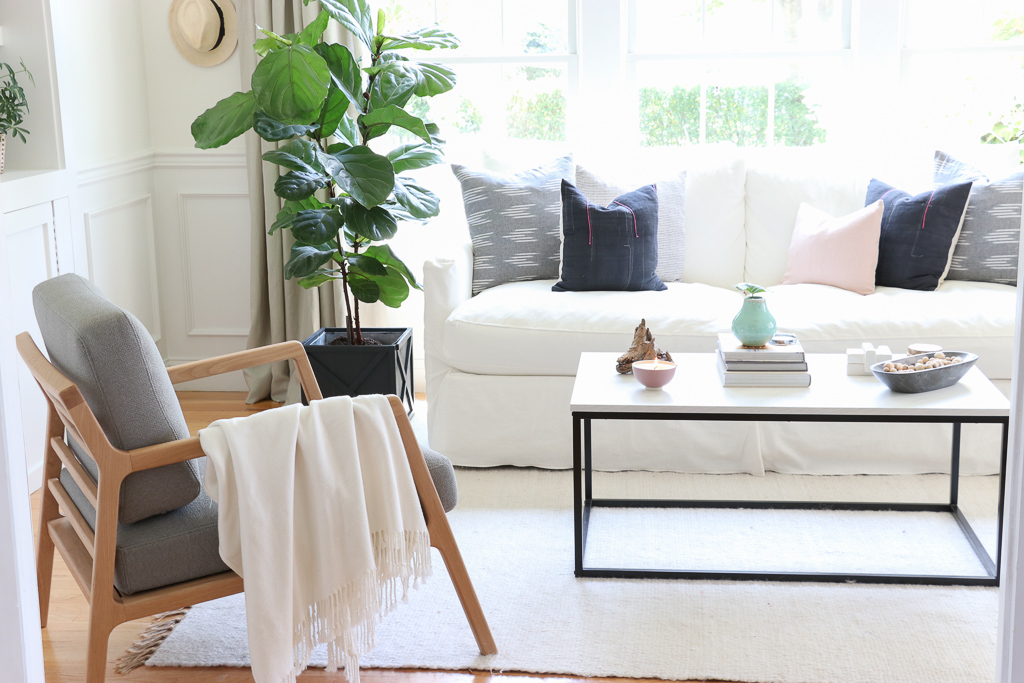 Denman Chair Article, White Slipcovered sofa, Woven Shade, White Walls, City Farmhouse & Co Pillows, Hats on Wall, Indigo Pillows