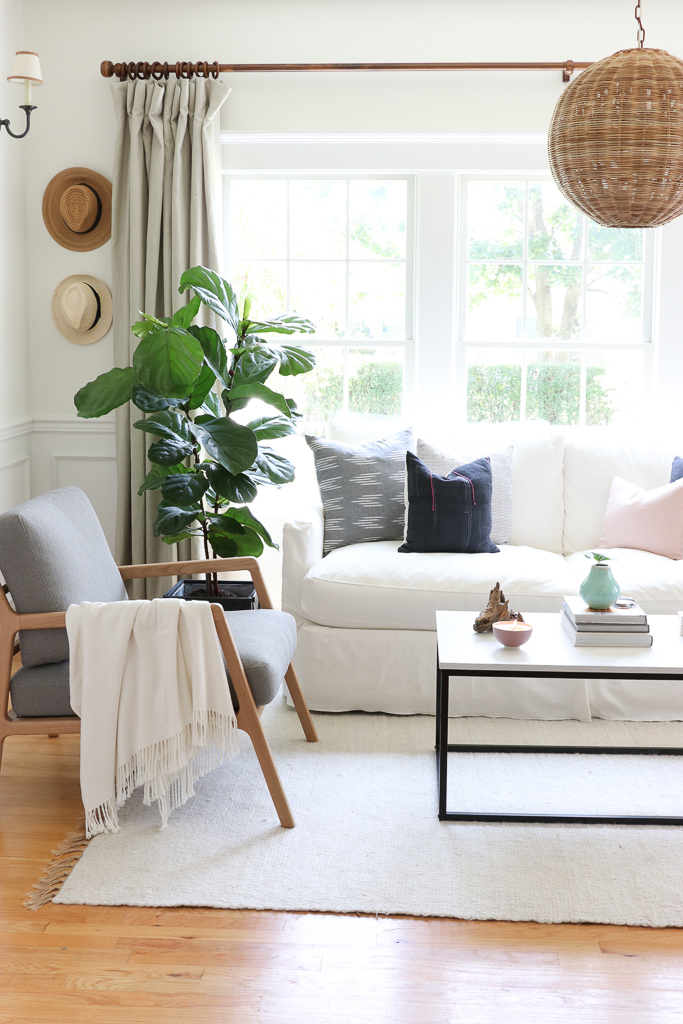 Denman Chair Article, White Slipcovered sofa, Woven Shade, White Walls, City Farmhouse & Co Pillows, Hats on Wall, Indigo Pillows