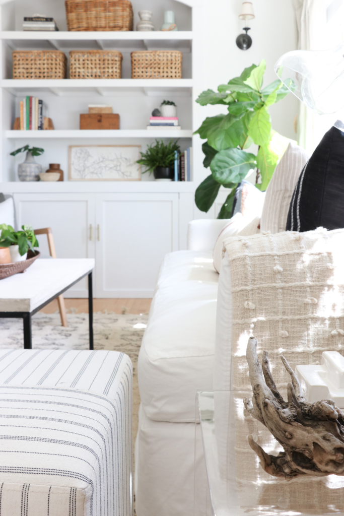 City Farmhouse fall den. Pure White walls and white slipcovered sofa.