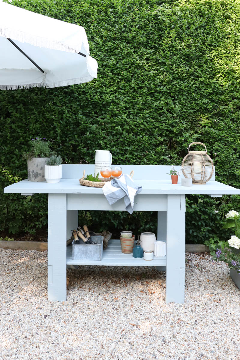 City Farmhouse by Jennifer OBrien. Free workbench turned into potting bench + outdoor bar. DIY pea gravel patio. Boothbay Gray by Benjamin Moore.