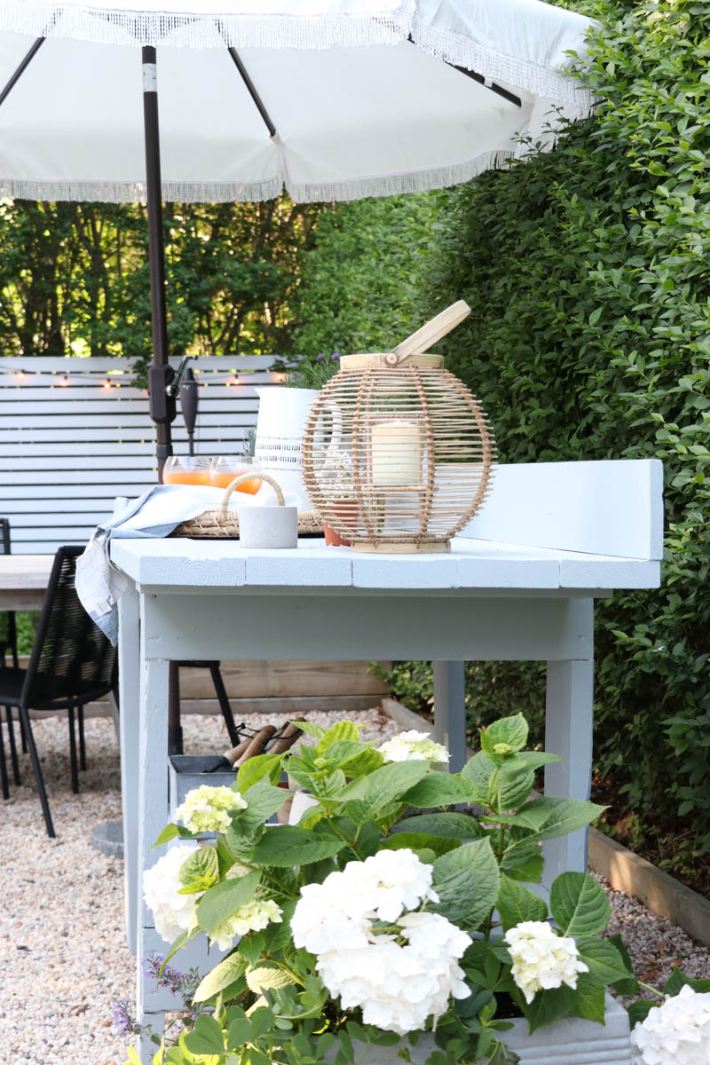 City Farmhouse by Jennifer OBrien. Free workbench turned into potting bench + outdoor bar. DIY pea gravel patio. Boothbay Gray by Benjamin Moore.